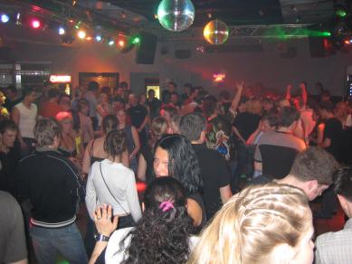 Abbildung 1:Blick in Richtung DJ/Hauptbar. Zu erkennen sind von links ca. ein viertel der Par36-Spots und dazwischen zwei Scanner, eine Box und abgeschaltet zwischen zwei Flowereffekten der 8er-Bar mit einigen Par56-Strahlern